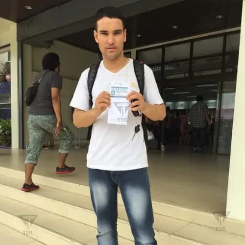 Client with backpack holding new Thai driving license at DLT