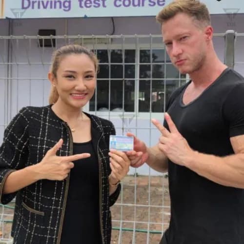 Couple at driving school after passing their test